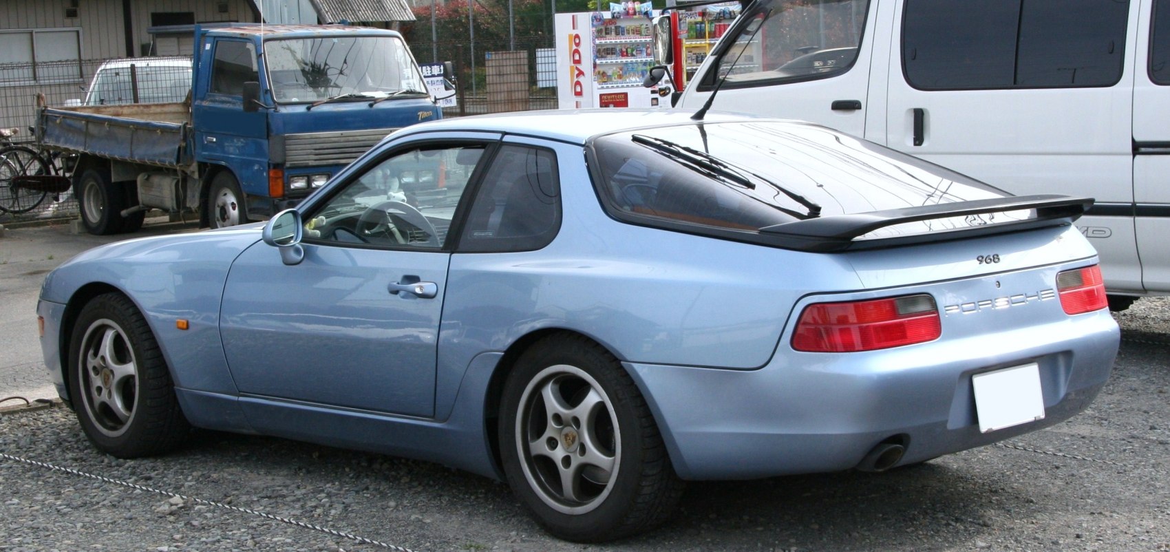 Rear side view of coupe with spoiler and alloy wheels