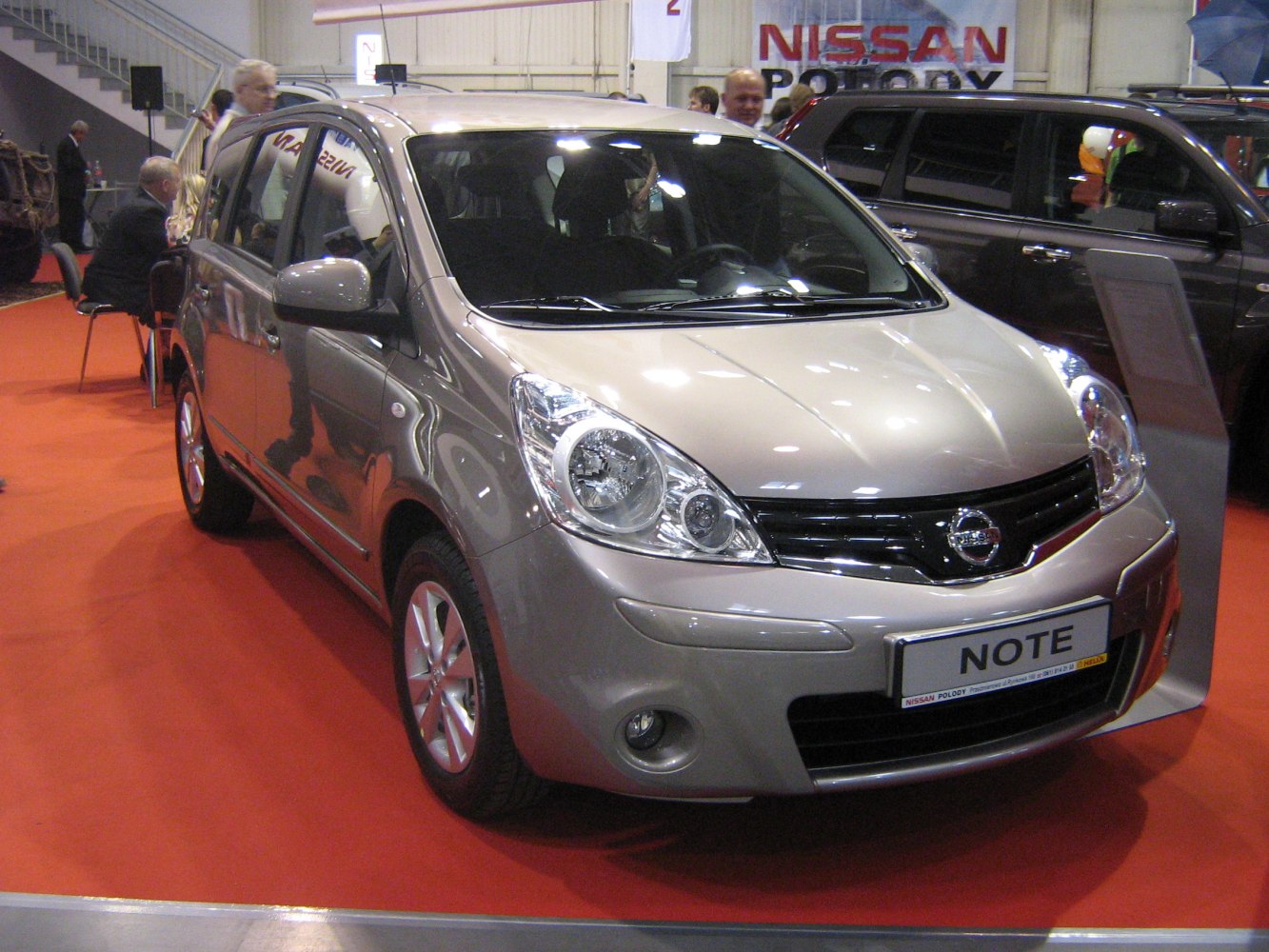 Compact hatchback with distinct large clear headlights and black grille.