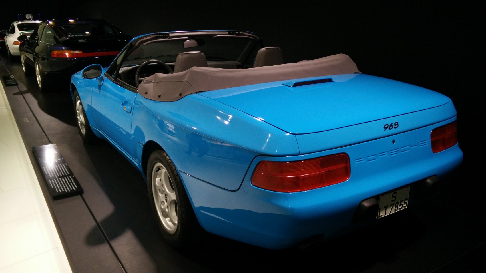 Blue convertible rear with soft top and rear lights detail.