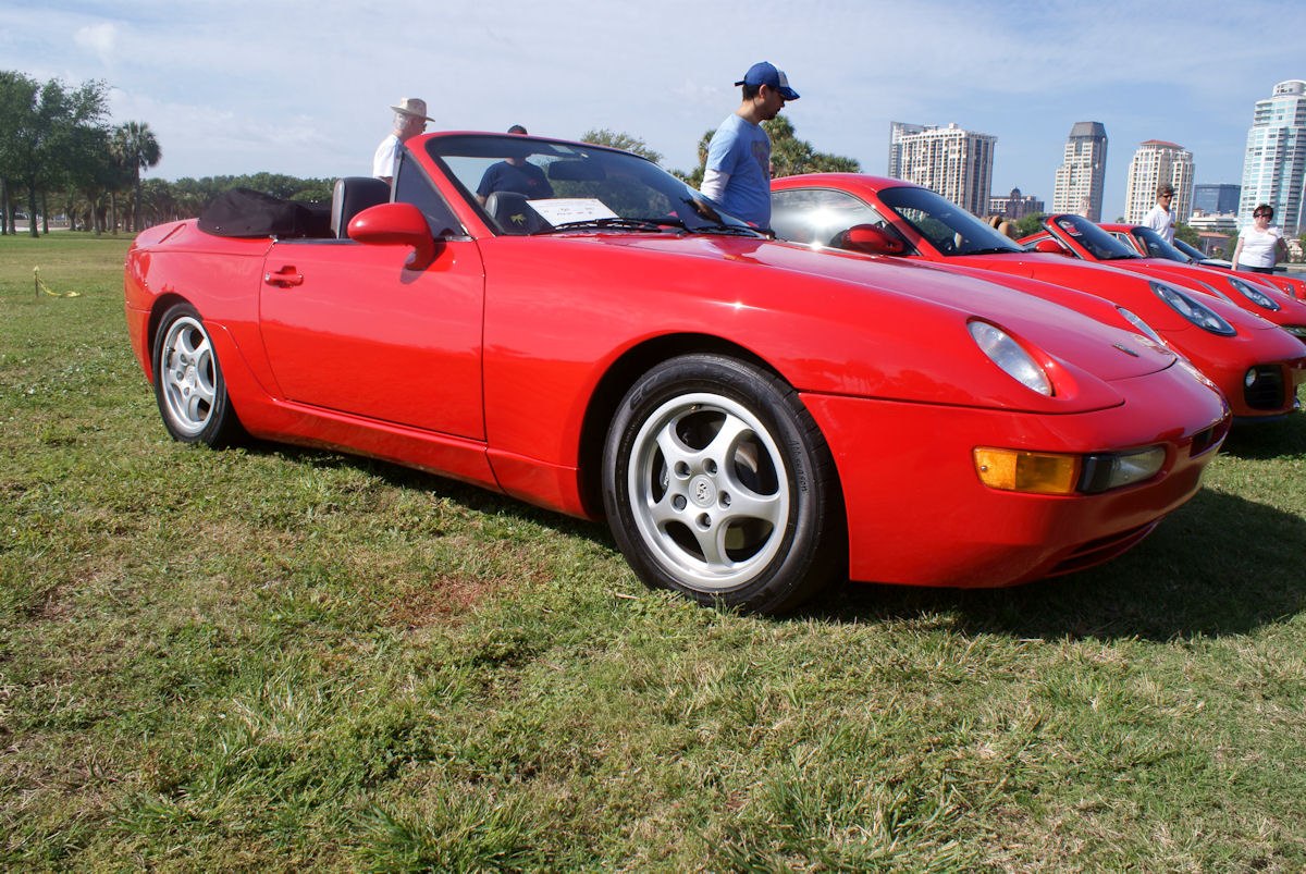 Red convertible sports car with pop-up headlights and alloy wheels