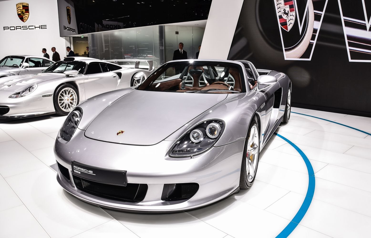 Silver convertible sports car with distinctive dual round headlights and open roof design