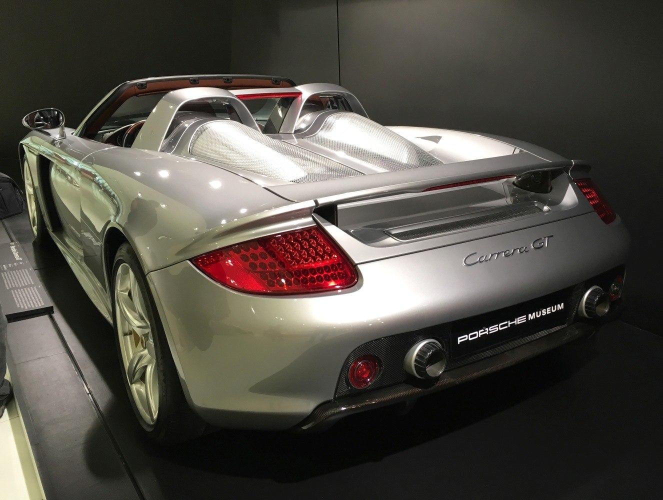 Rear view of silver sports car with twin exhaust and aerodynamic design