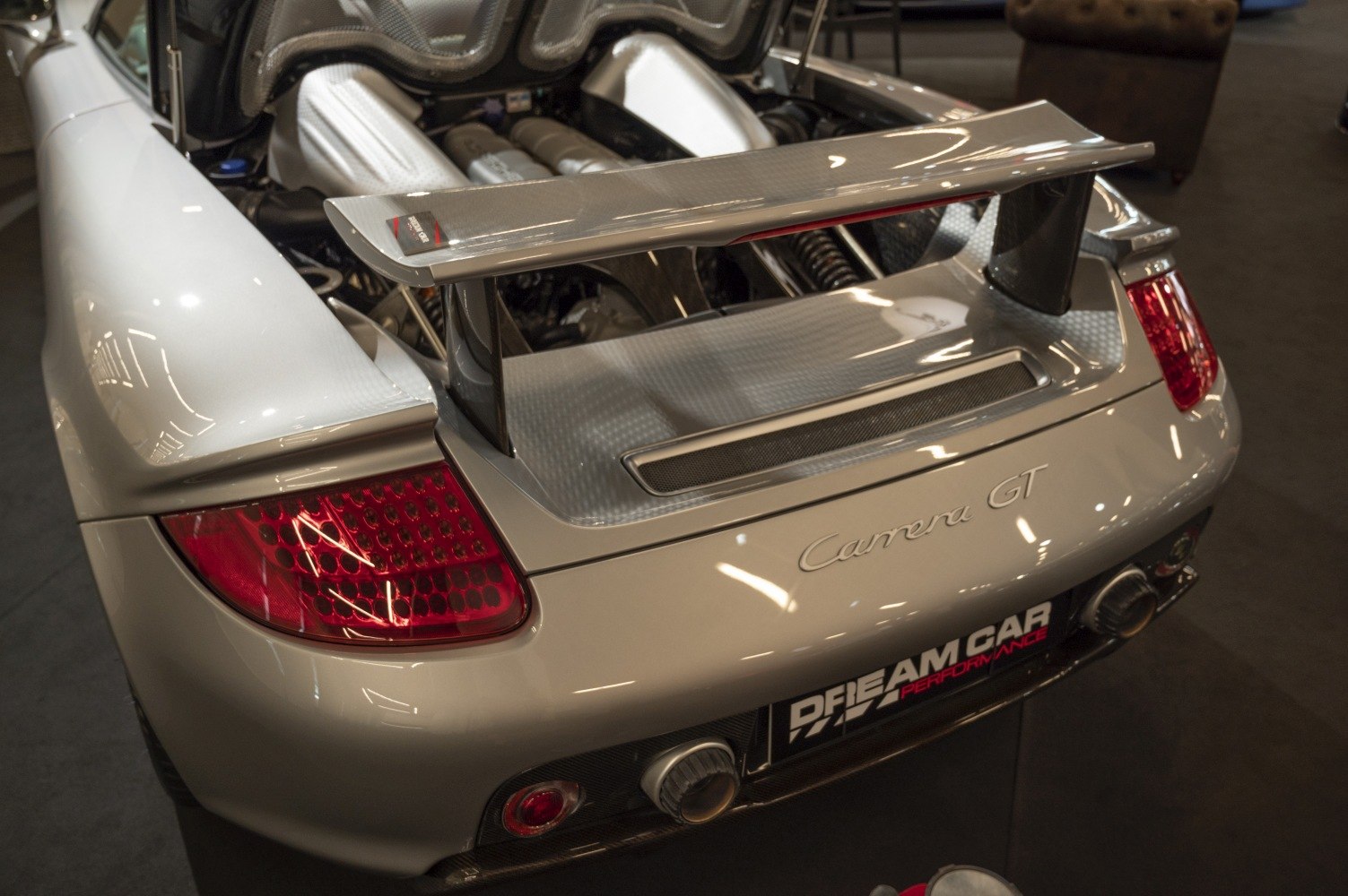 Rear wing and exposed engine detail of a sports car.