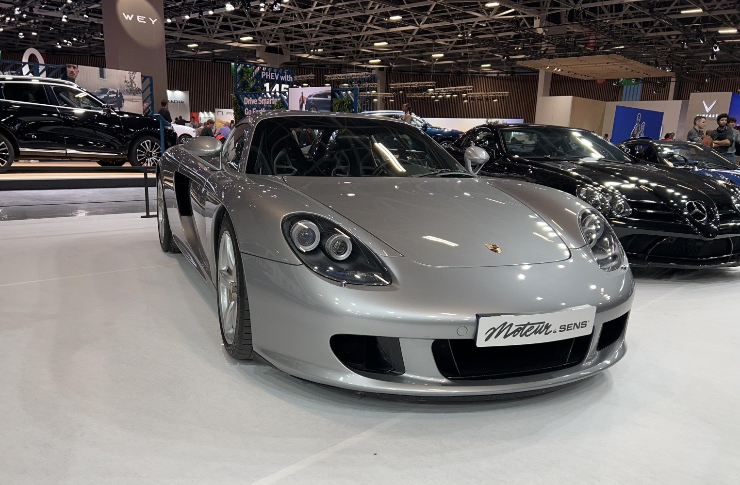 Silver supercar with dual round headlights and aerodynamic front fascia