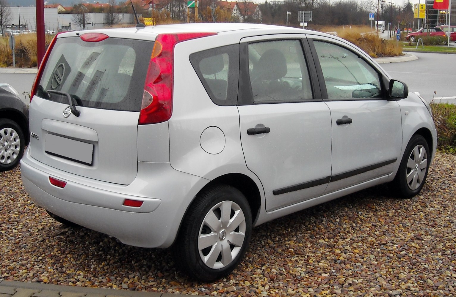 Rear side view of compact hatchback with distinctive tail lights and small rear window
