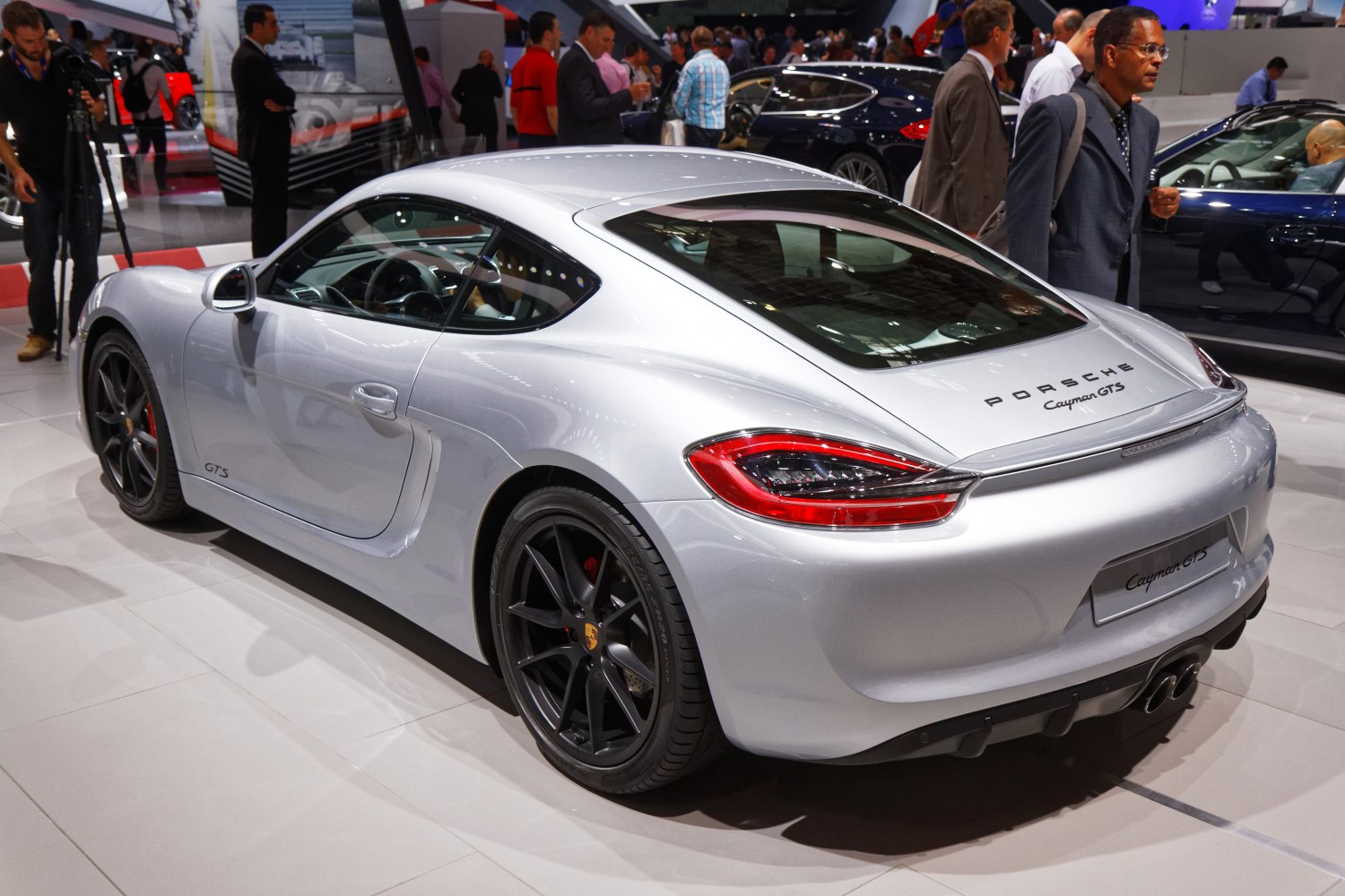 Rear and side view of a silver sports coupe with black wheels