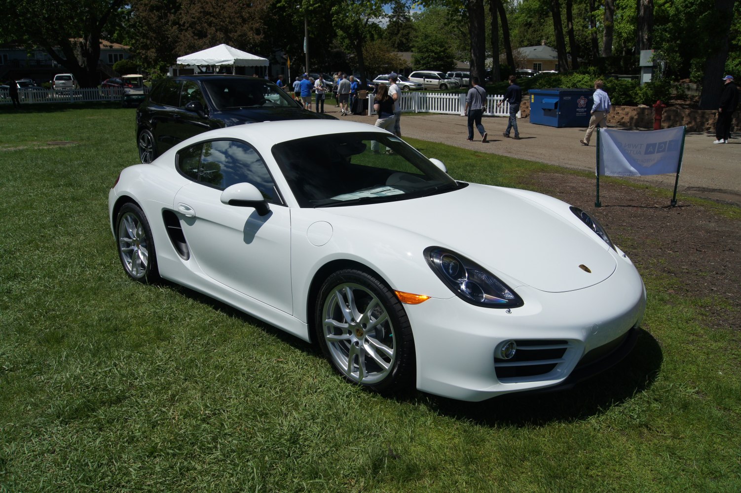 White sports coupe front and side view on grass.