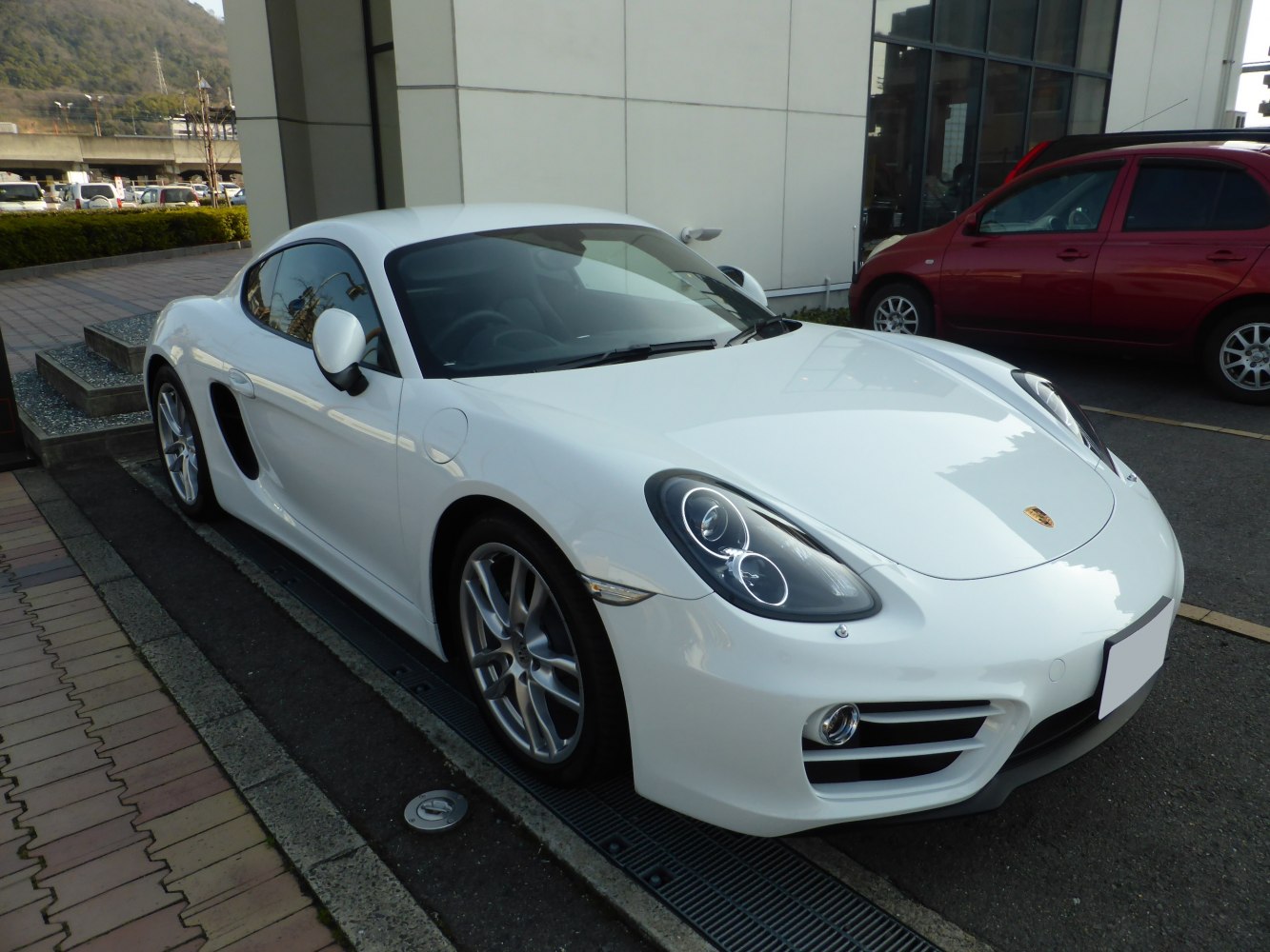 White sports coupe with LED headlights and alloy wheels, front three-quarter view