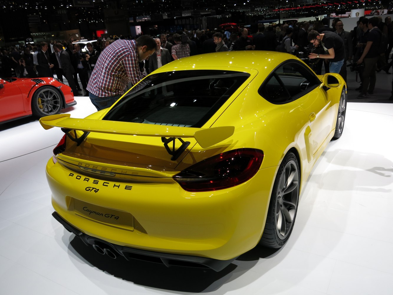 Yellow sports coupe rear with large fixed spoiler and dual exhausts