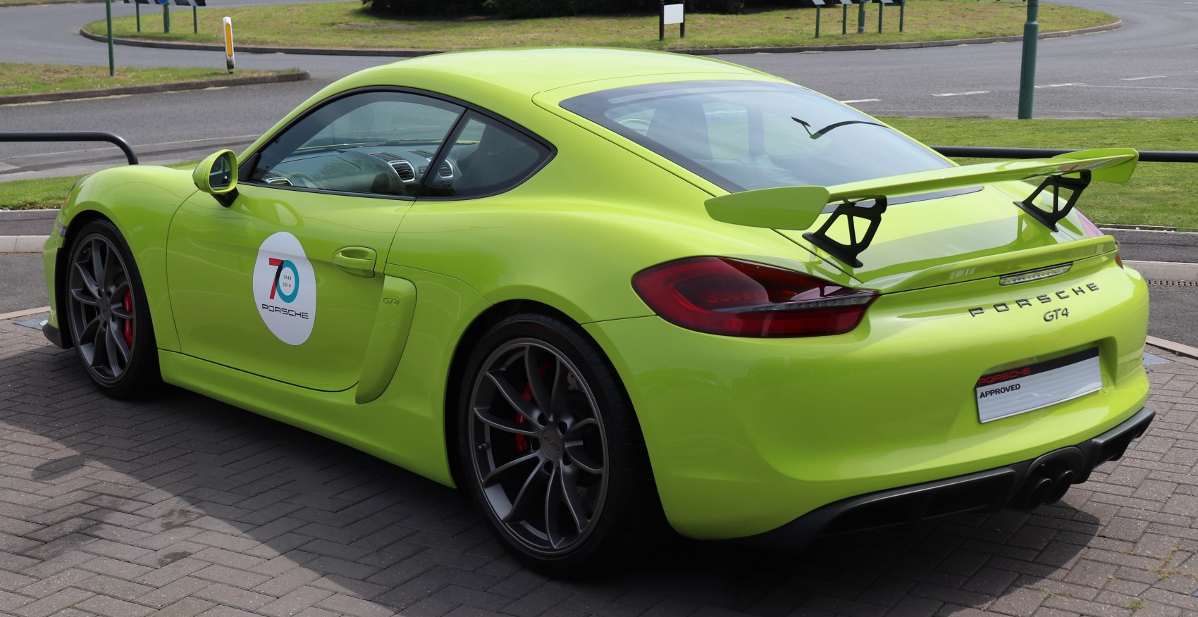Rear side view of sports car with large spoiler and alloy wheels