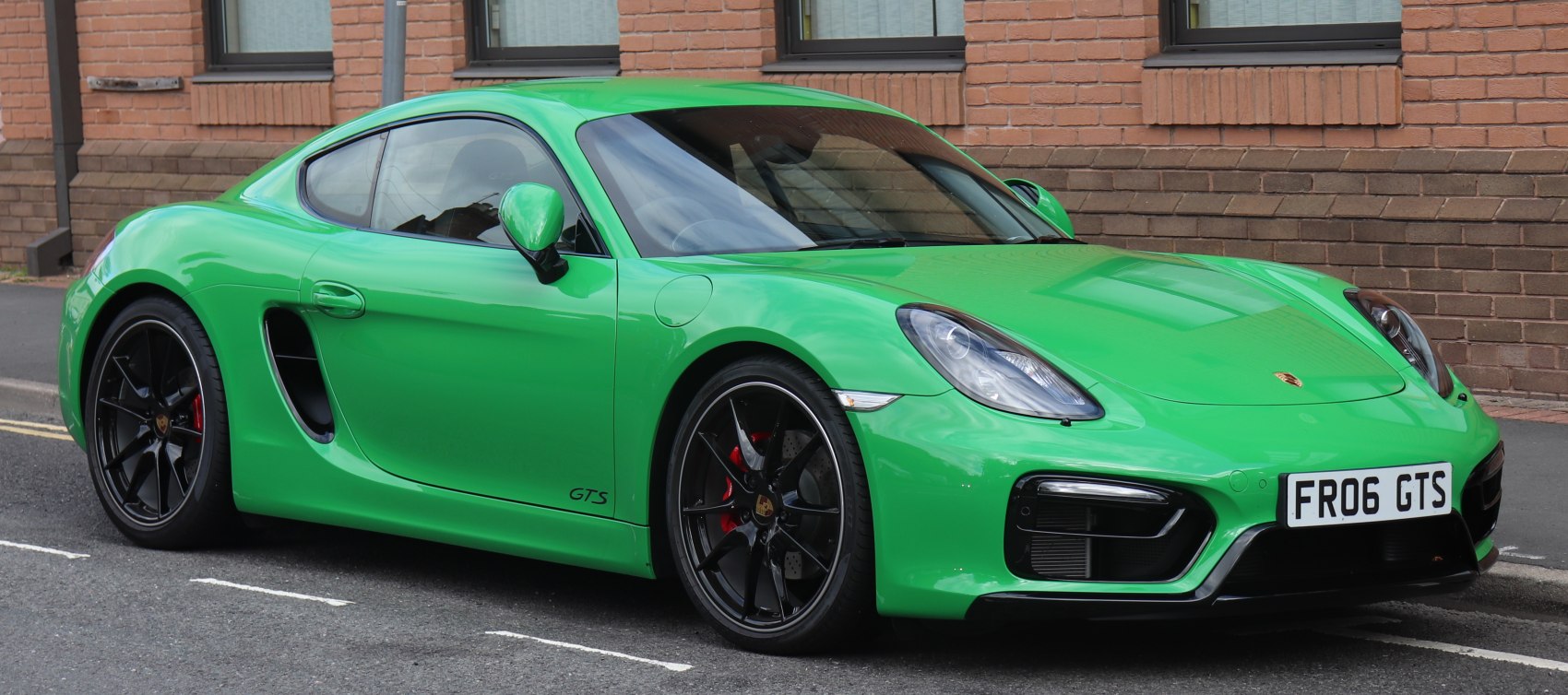 Green sports coupe with black wheels and aerodynamic design