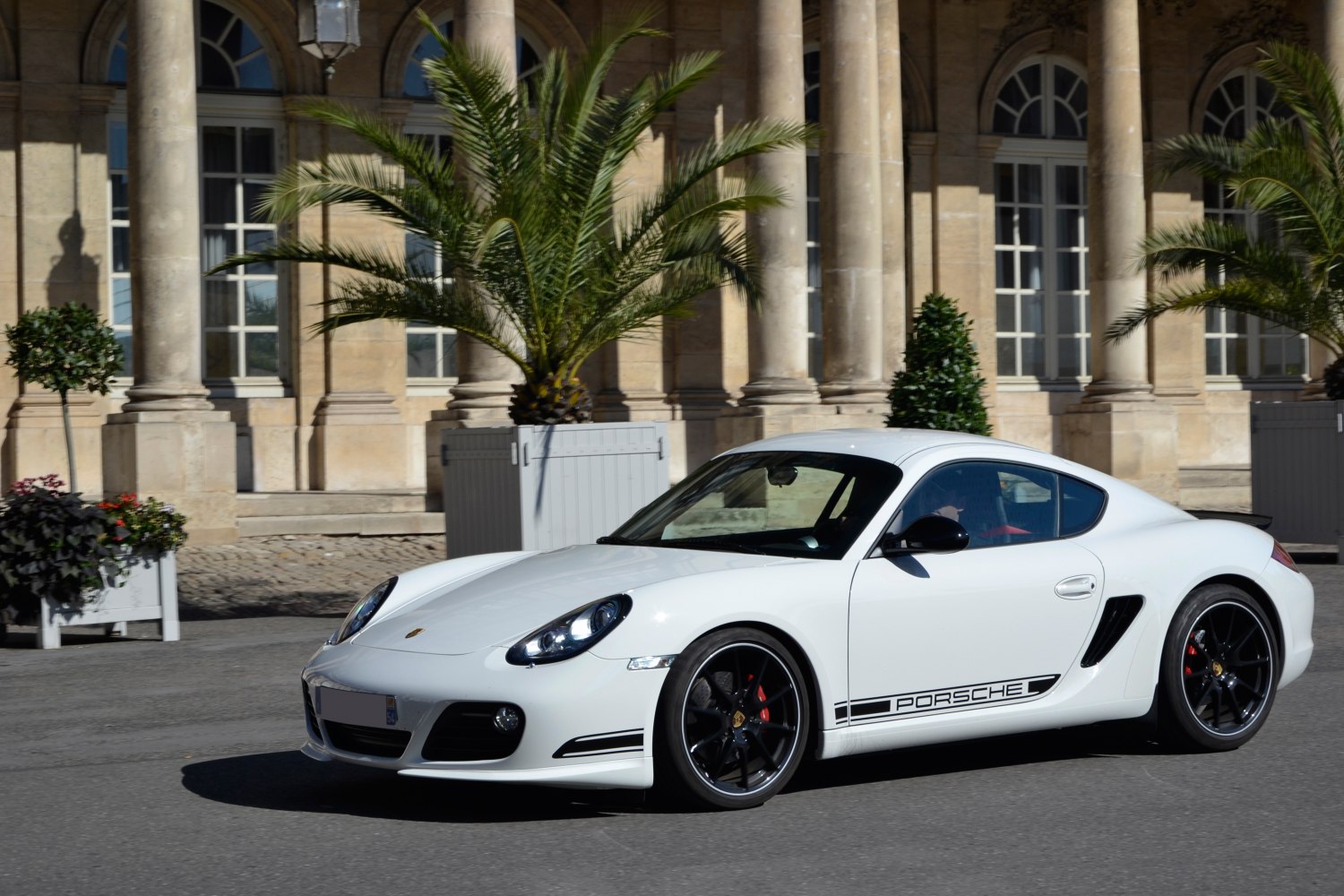 Side profile of a sleek sports coupe with black wheels and Porsche decal