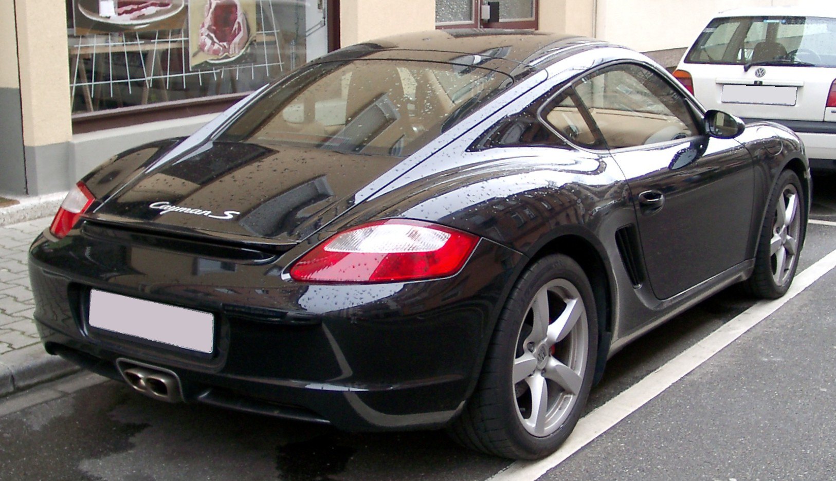 Rear-side perspective showing sporty taillights, roofline, spoiler, and side vent