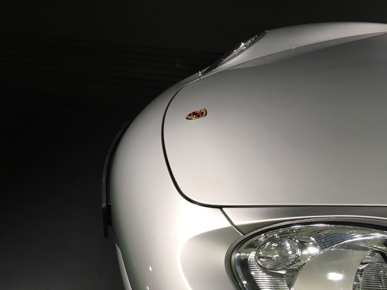 Close-up of front hood and headlight on silver sports car