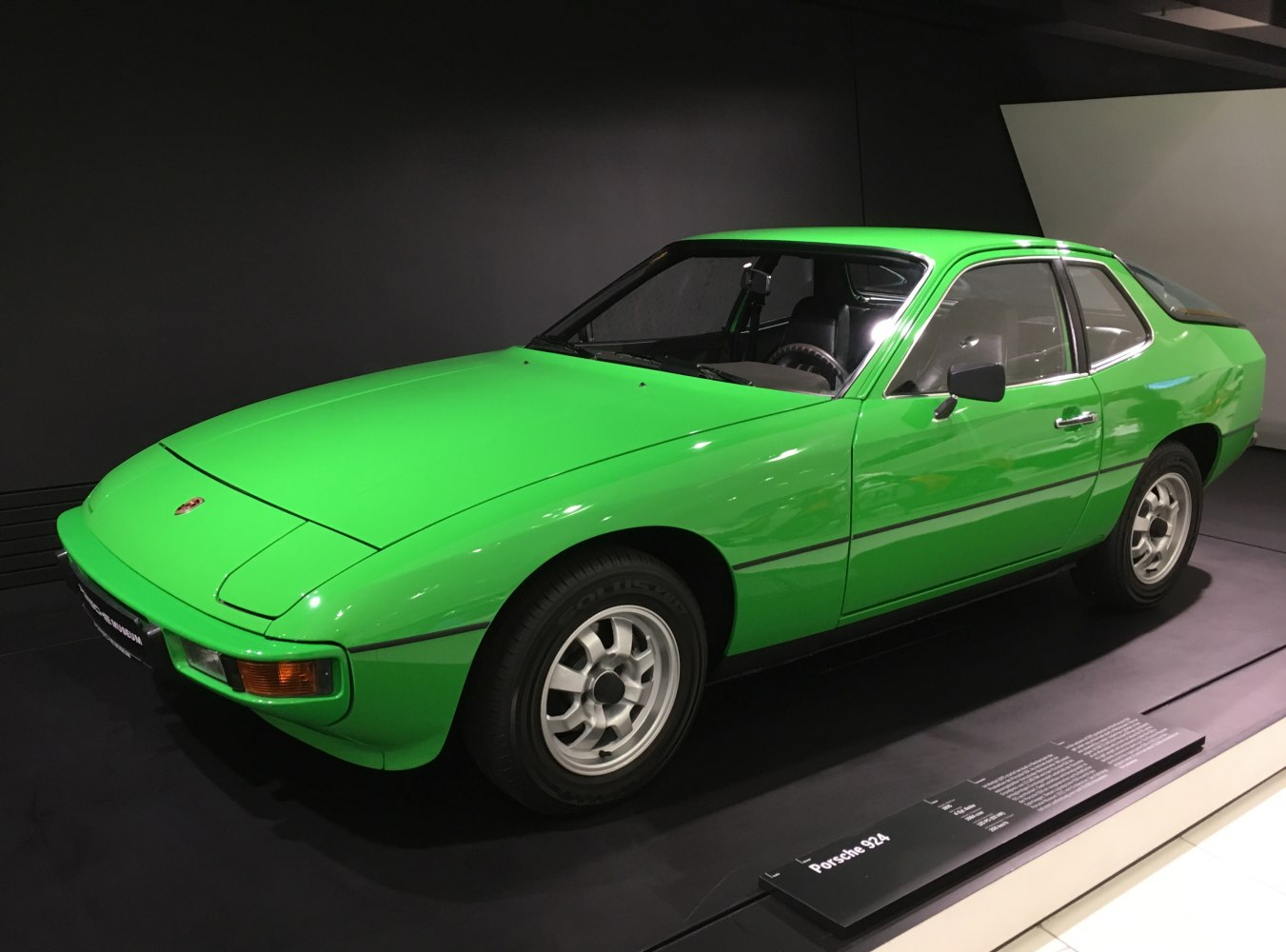 Vibrant green vintage sports coupe with pop-up headlights and alloy wheels