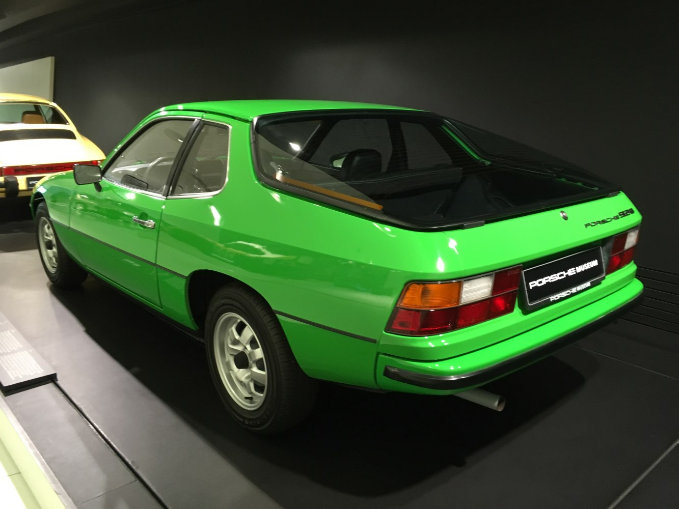 Rear side view of a green vintage hatchback with distinctive tail lights