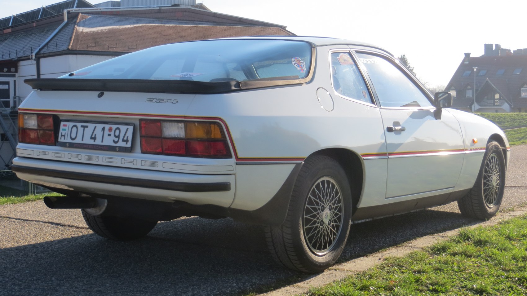 Rear side view with spoiler, tail lights, and mesh alloy wheels