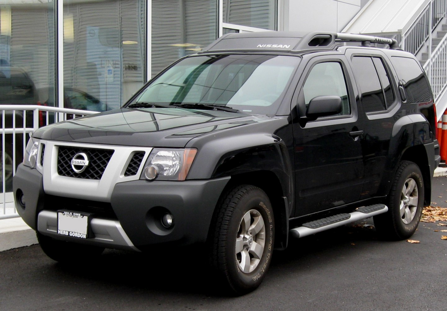 Black SUV with roof storage rack and side steps