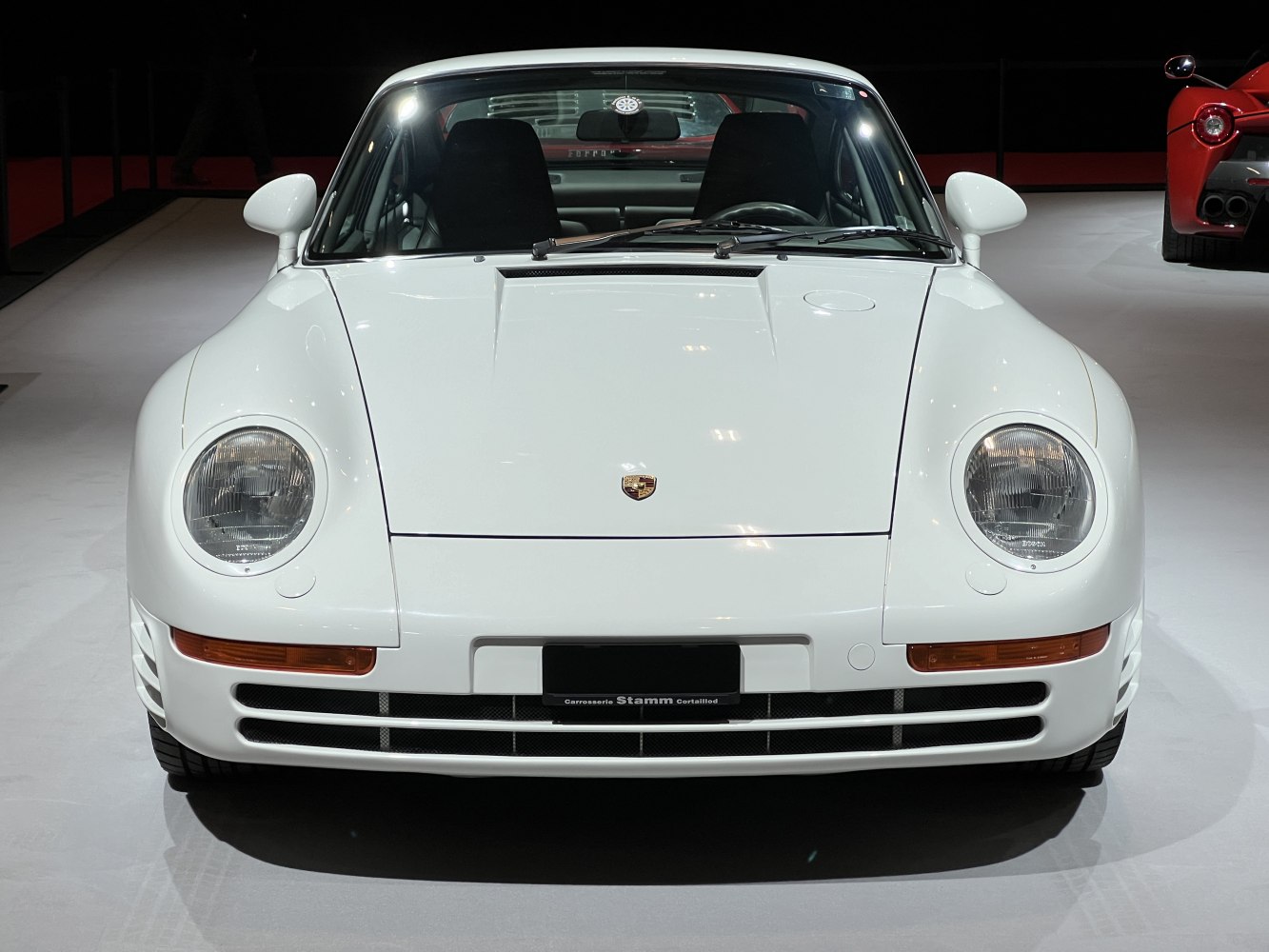 Front view showing round headlights and aerodynamic bumper of a classic sports car.