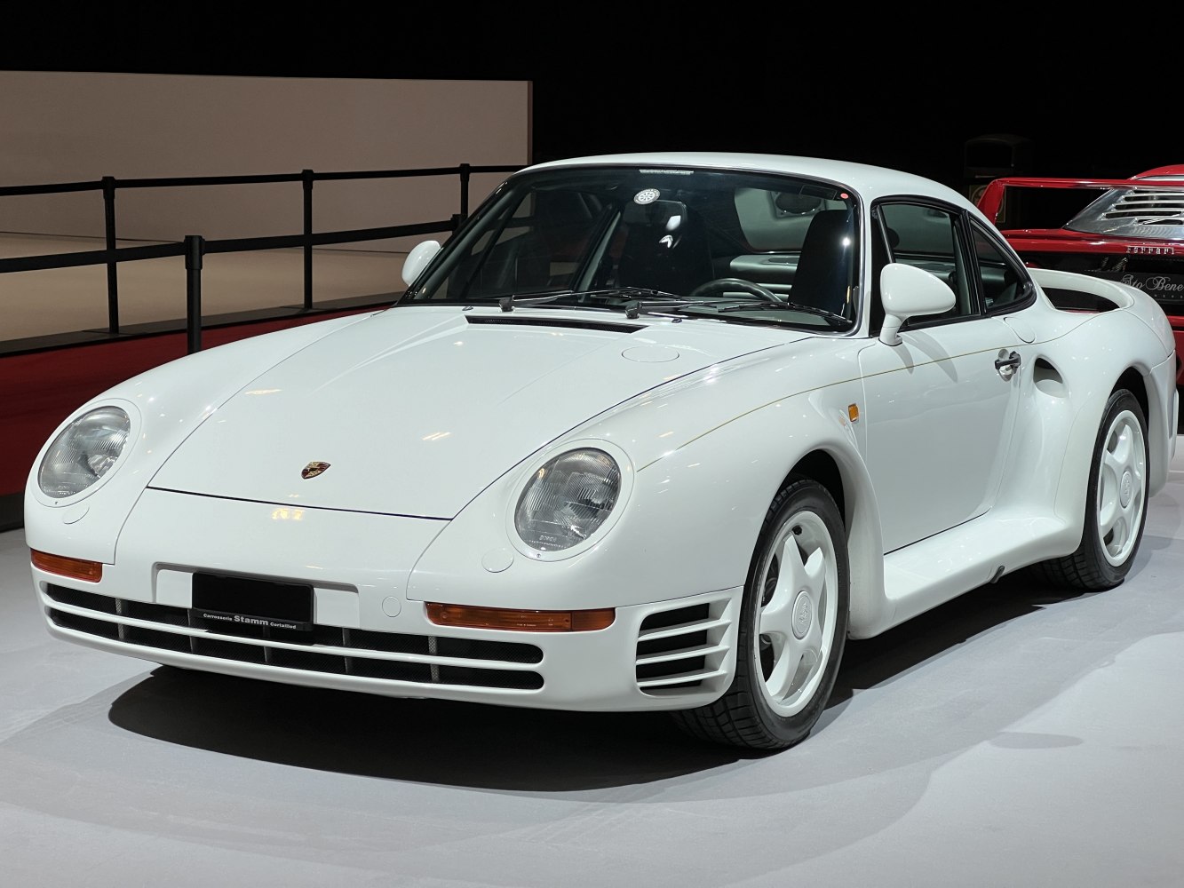 White sports coupe with prominent aerodynamic front and side vents, round headlights