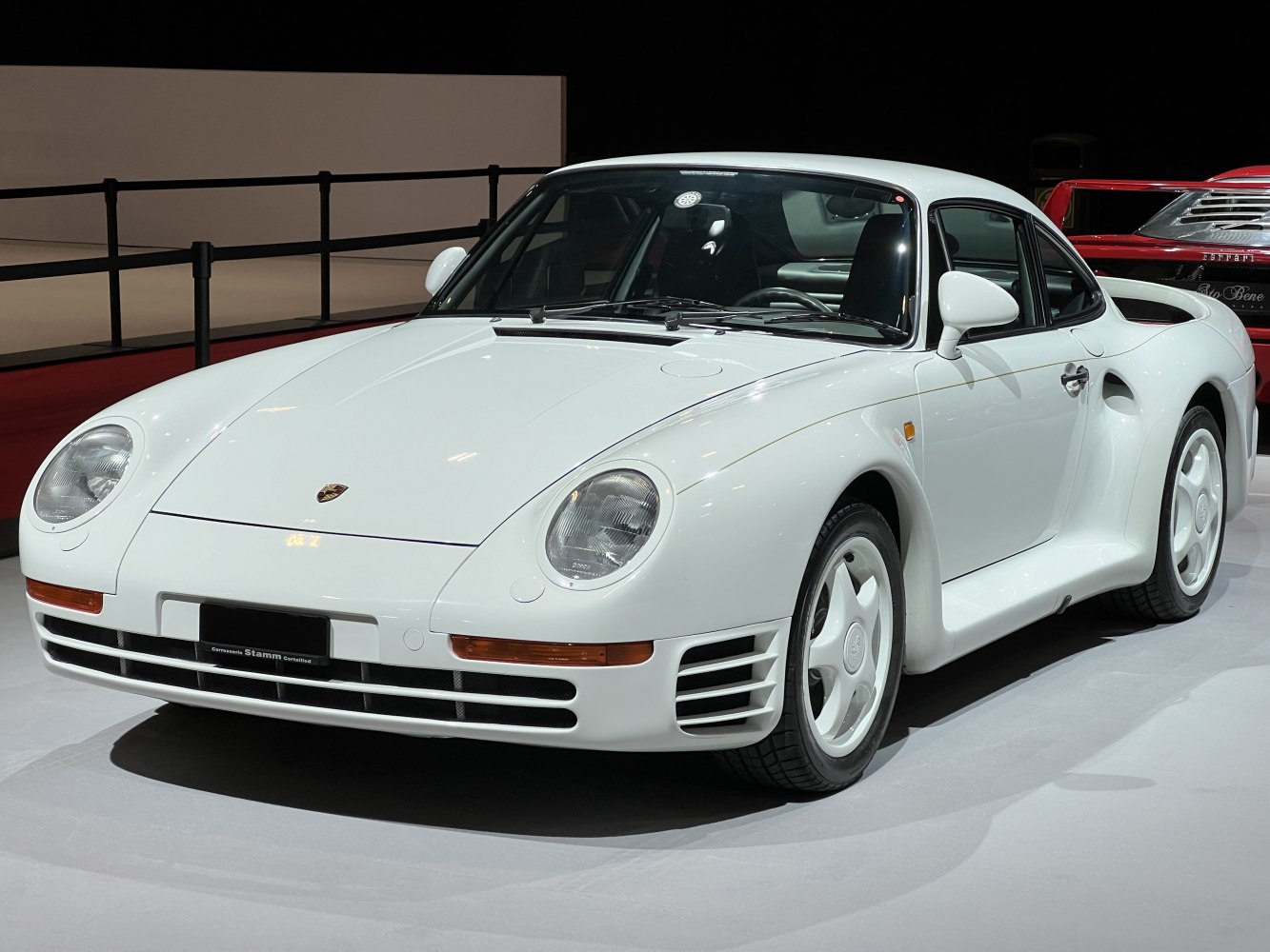 White vintage sports coupe with rounded headlights and aerodynamic body.