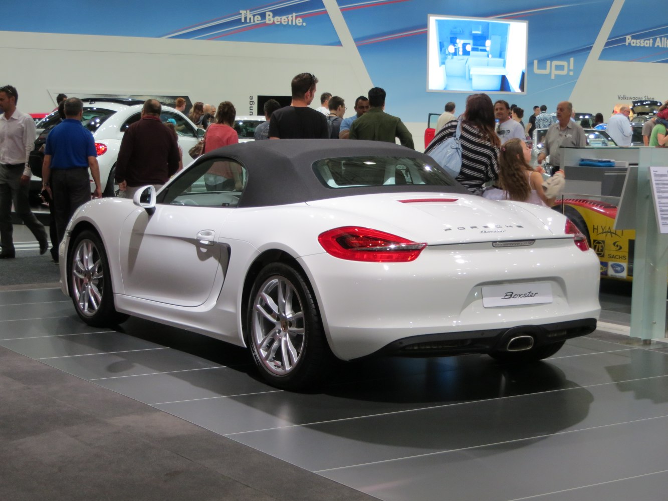 Rear view of convertible with soft top, distinct taillights, and central exhaust