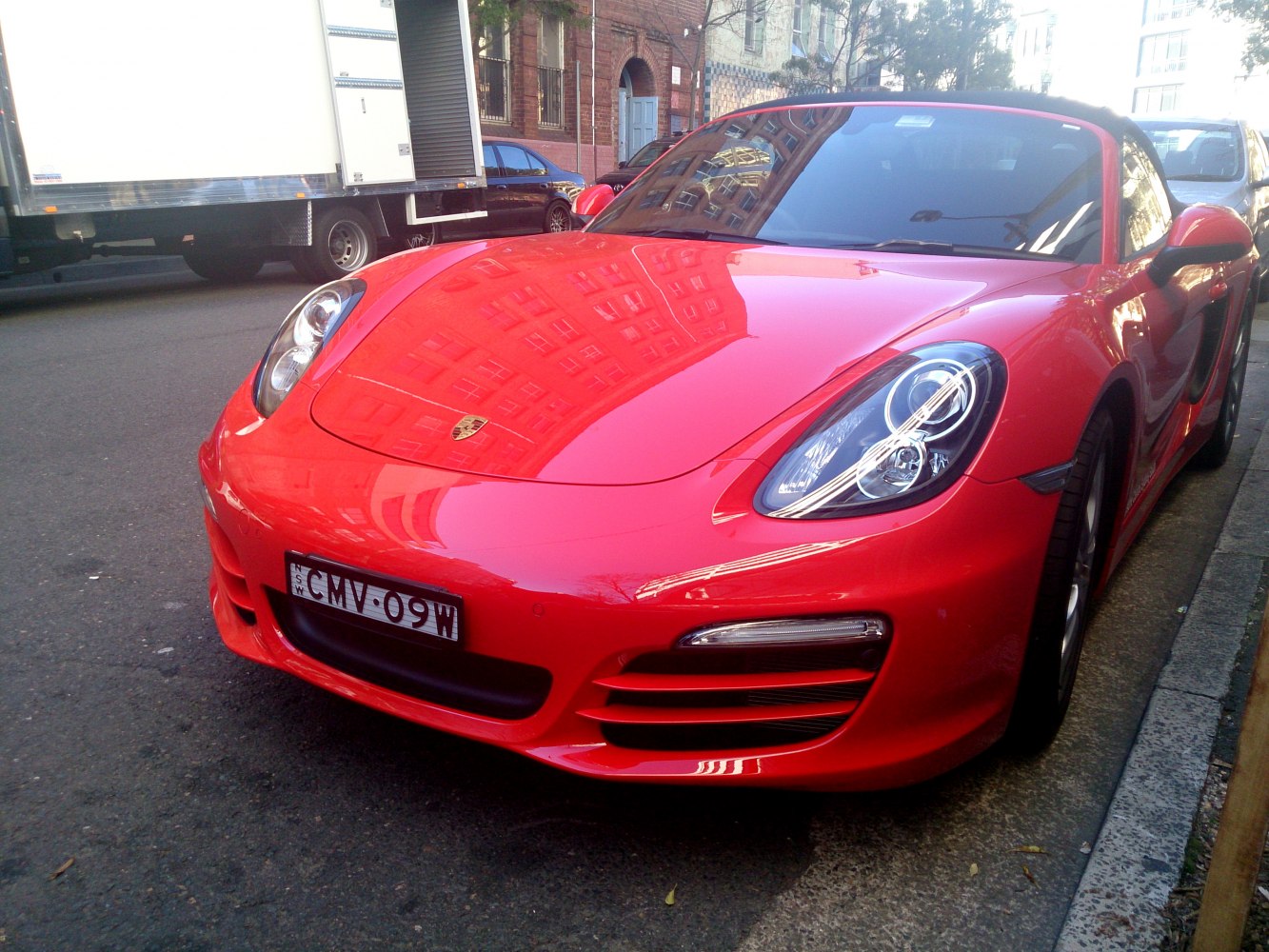 Red convertible sports car front with LED headlights and aerodynamic design