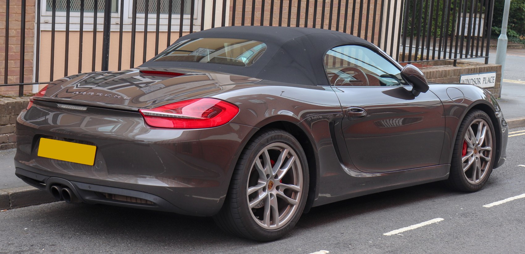 Rear view of a convertible with soft top and dual exhaust.