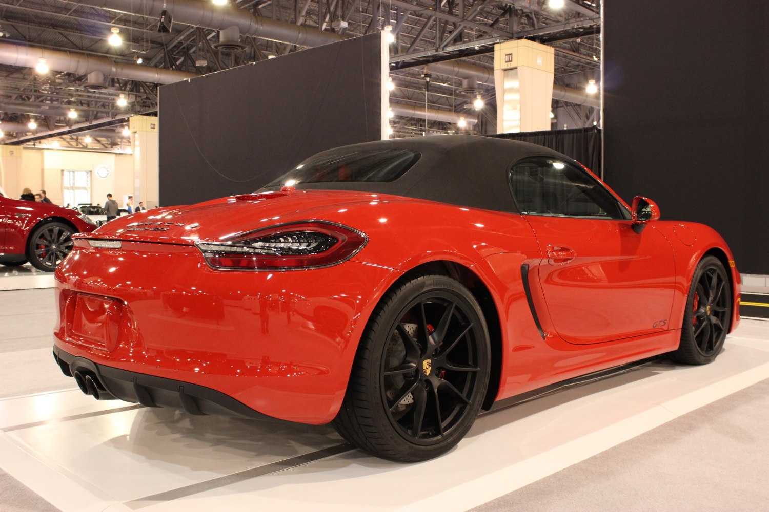 Rear view of red convertible with black wheels and soft top