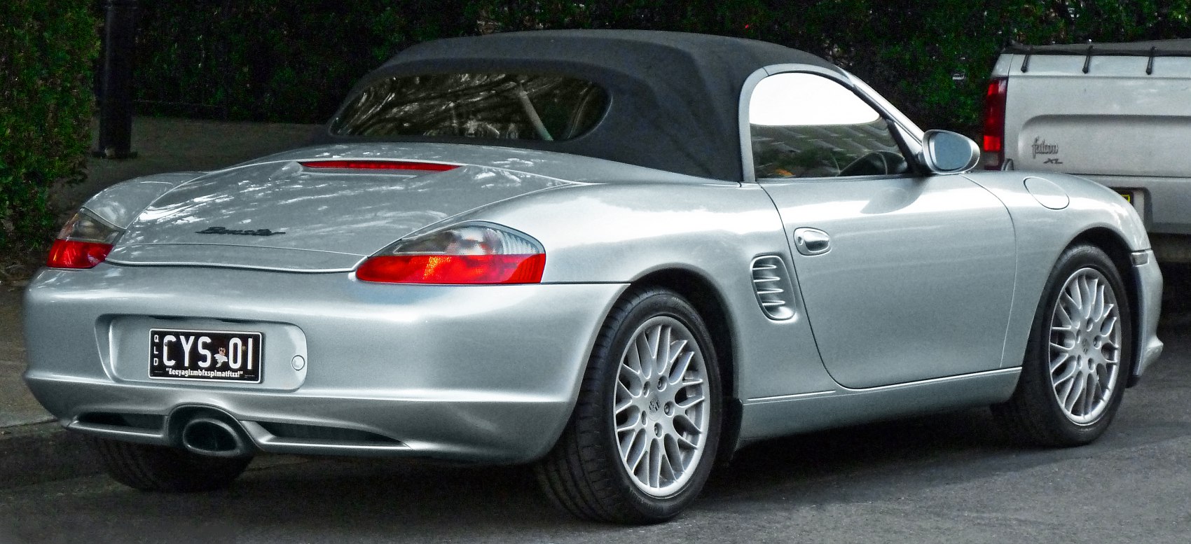 Silver convertible with soft top and rear design.