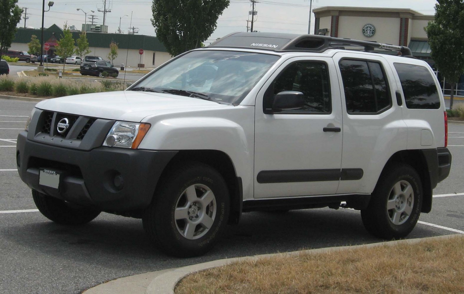 White SUV front-side view with roof rack and black trim