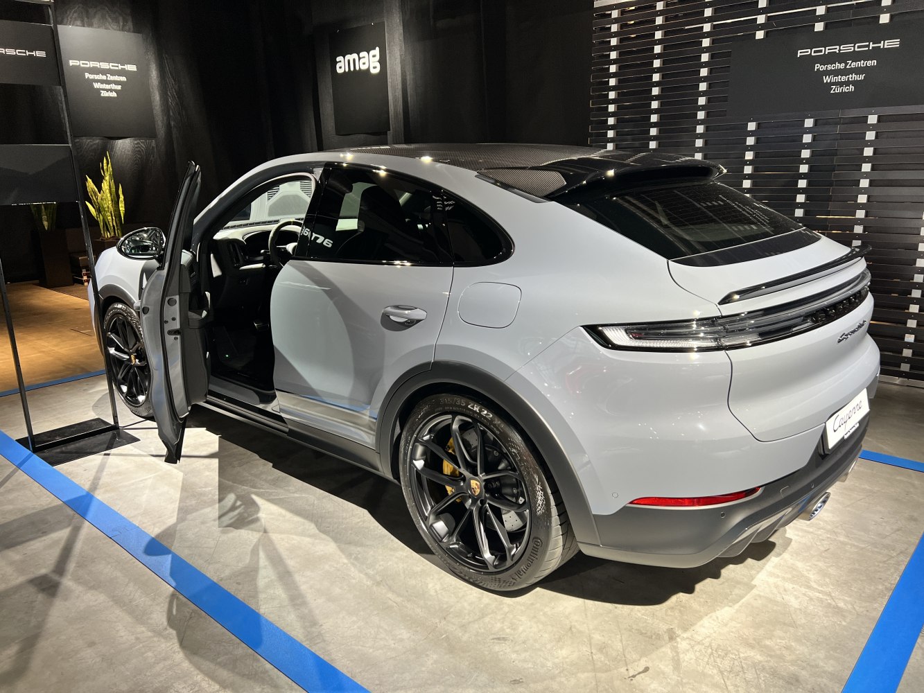 Rear side view of SUV with open driver door and black alloy wheels