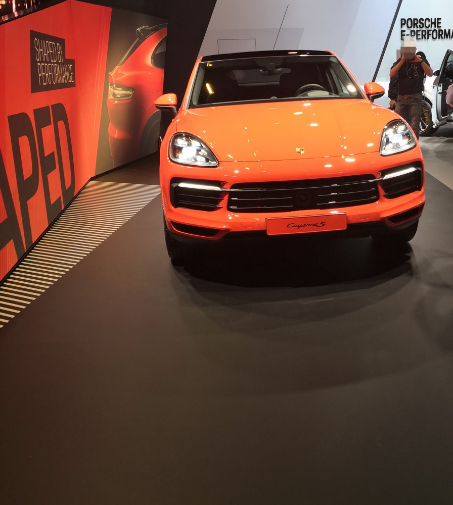 Front view of bright orange SUV with LED headlights and wide grille.