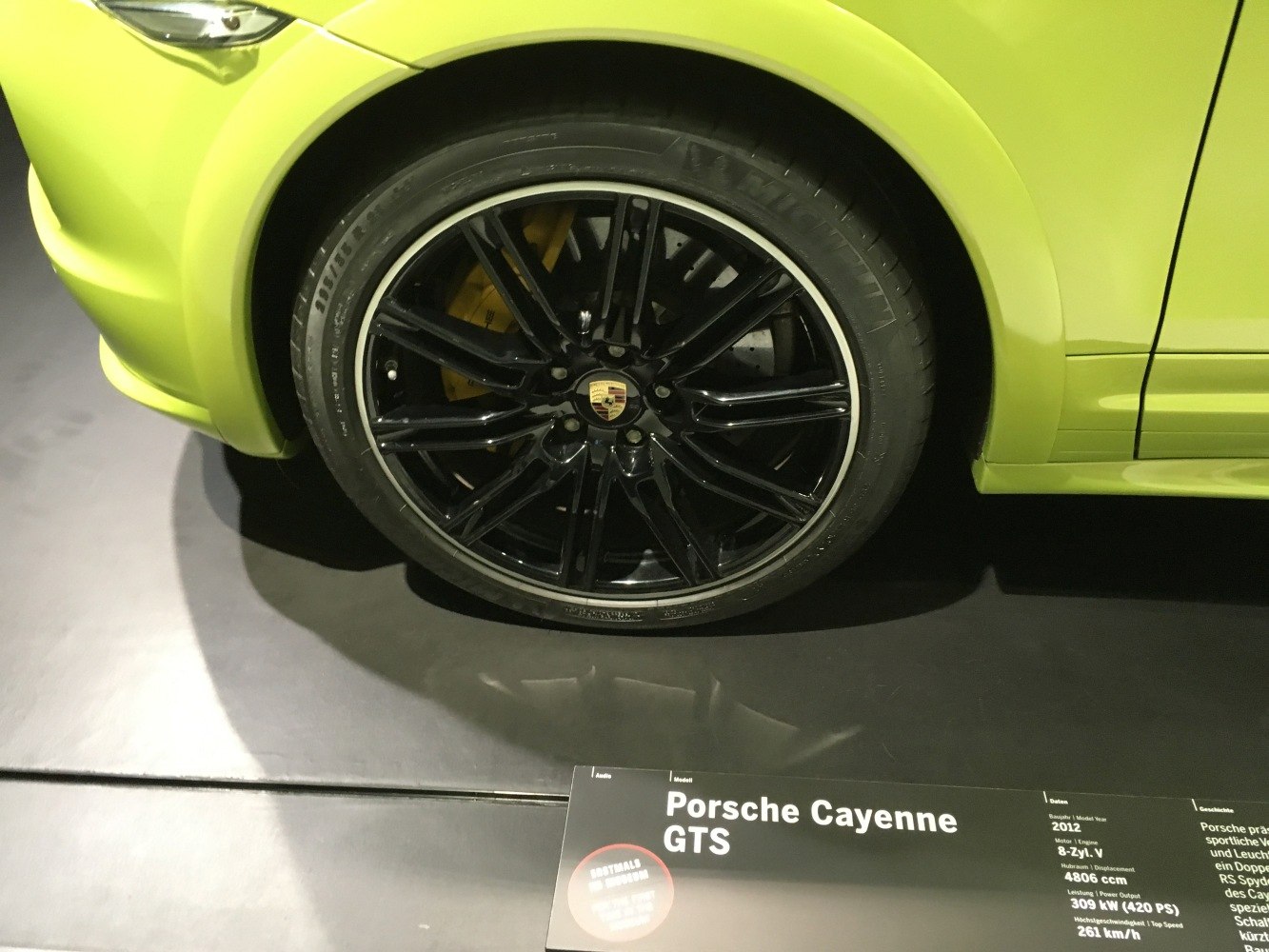 Black alloy wheel with yellow brake caliper on bright SUV fender