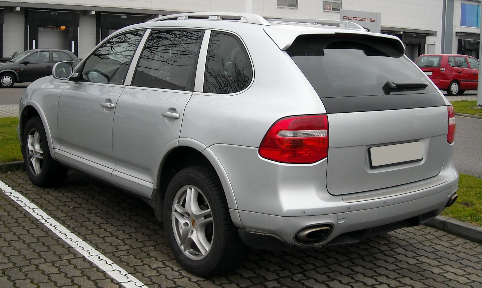 Rear view of silver SUV with tail lights and dual exhausts