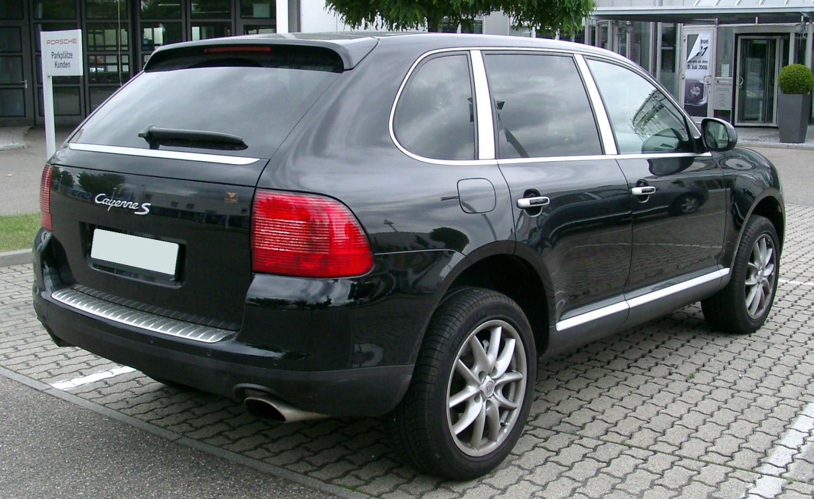 Rear side view of an SUV with alloy wheels and rear window spoiler