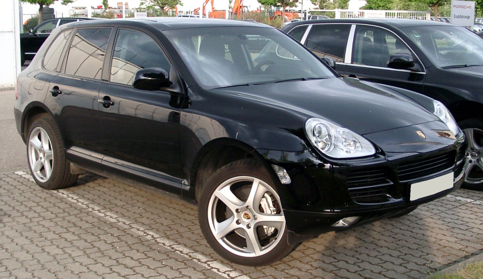 Front side view of luxury SUV with distinctive headlights and five-spoke alloy wheels
