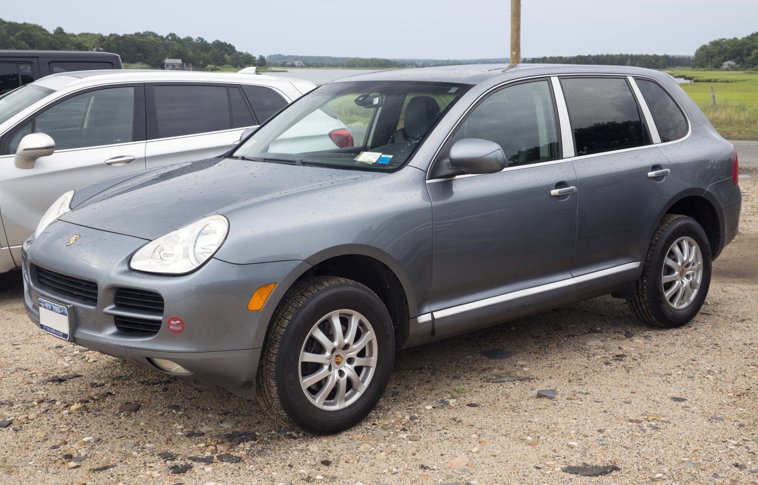 Front and side view of SUV with prominent headlights and alloy wheels