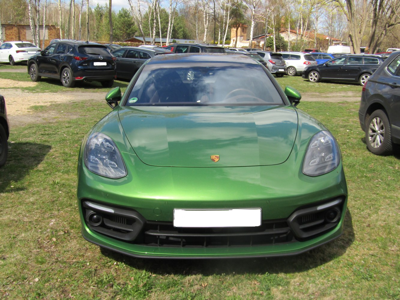 Close-up view of sleek headlights and sporty front grille of a metallic green sedan