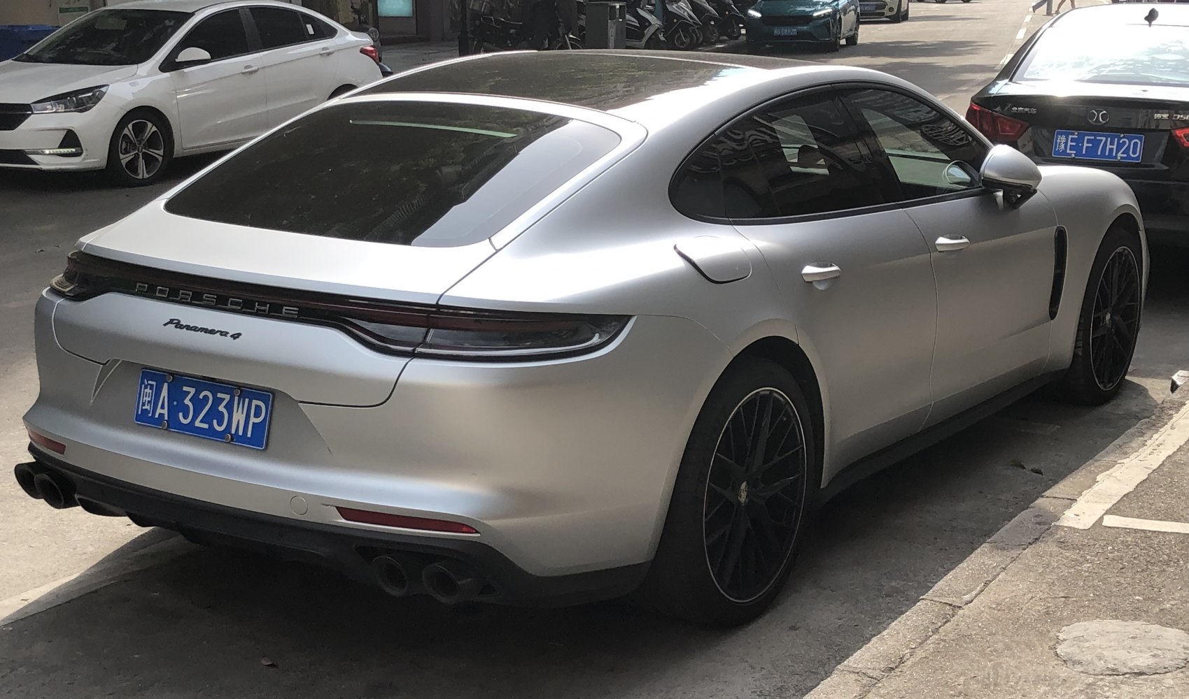 Rear and side view of a silver luxury sedan with quad exhausts and sleek taillight design