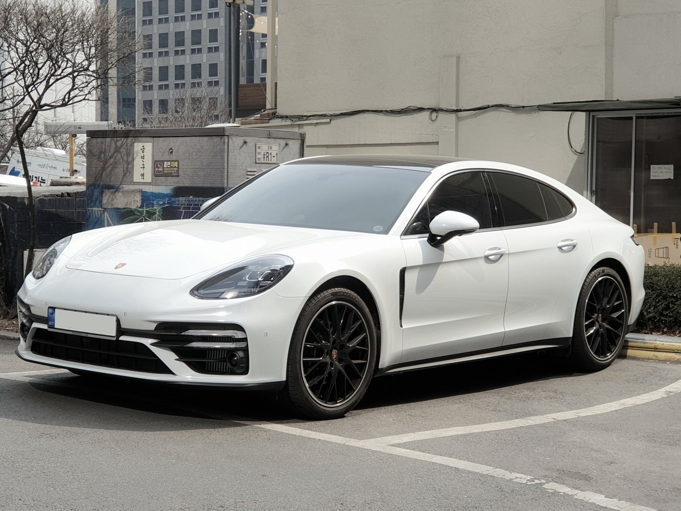 White four-door luxury sedan with black alloy wheels and sleek headlights