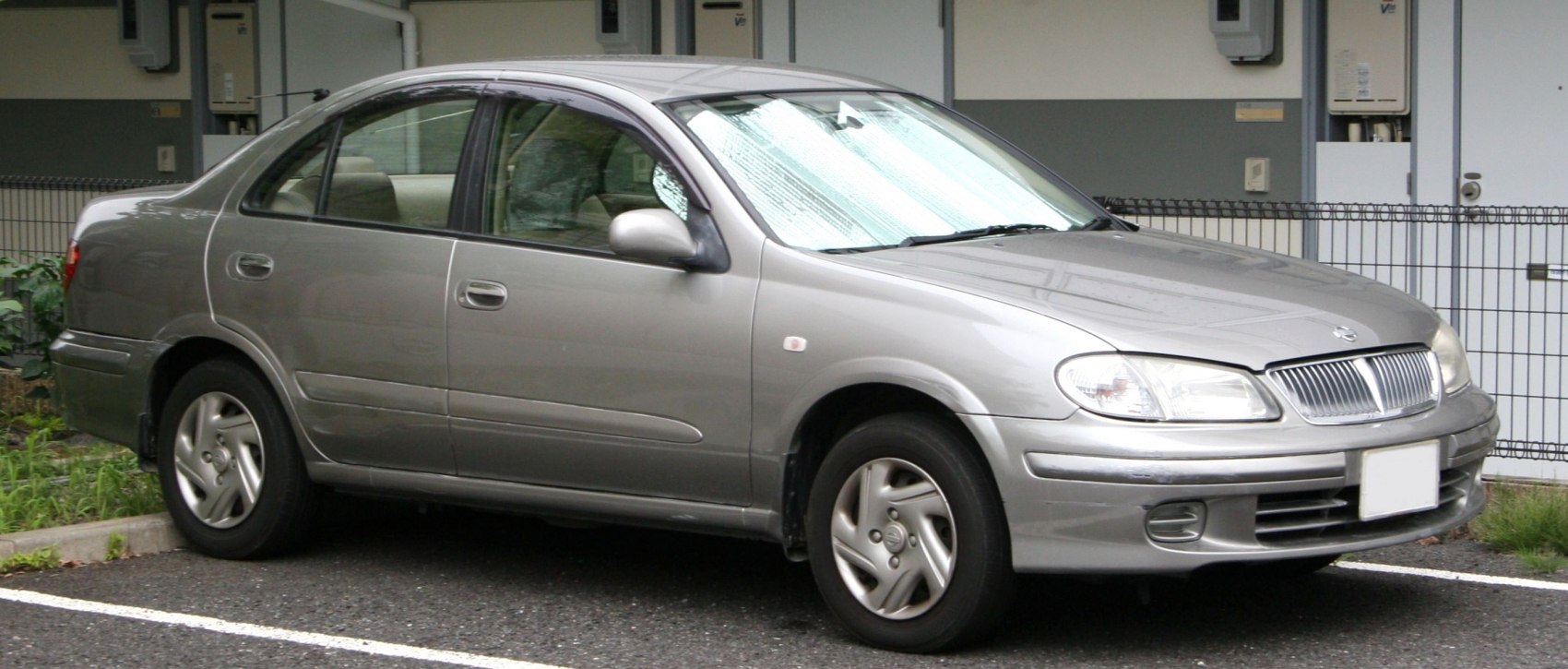Silver sedan with rounded design, clear headlights, and 5-spoke alloy wheels