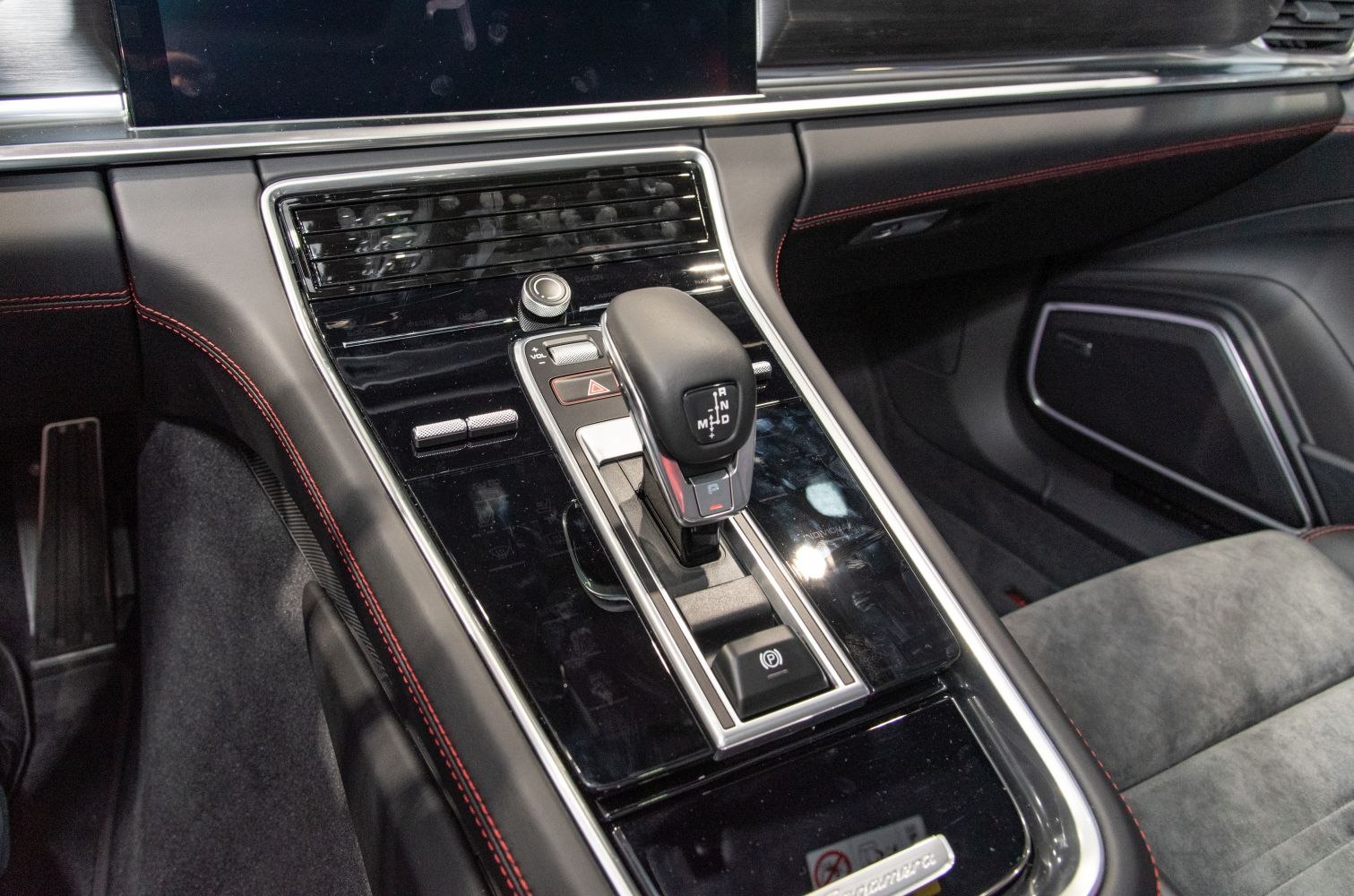 Interior gear shift and control panel with sleek design and red stitching