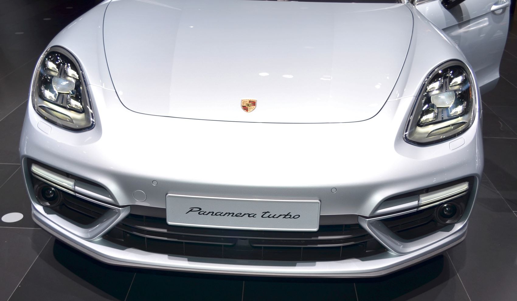 Front view of luxury sedan with distinctive LED headlights and sleek design.