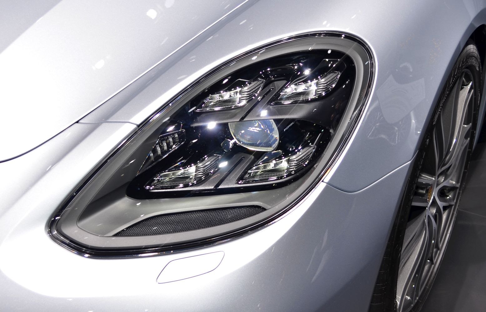 Close-up of modern headlight and front wheel with sleek alloy rim