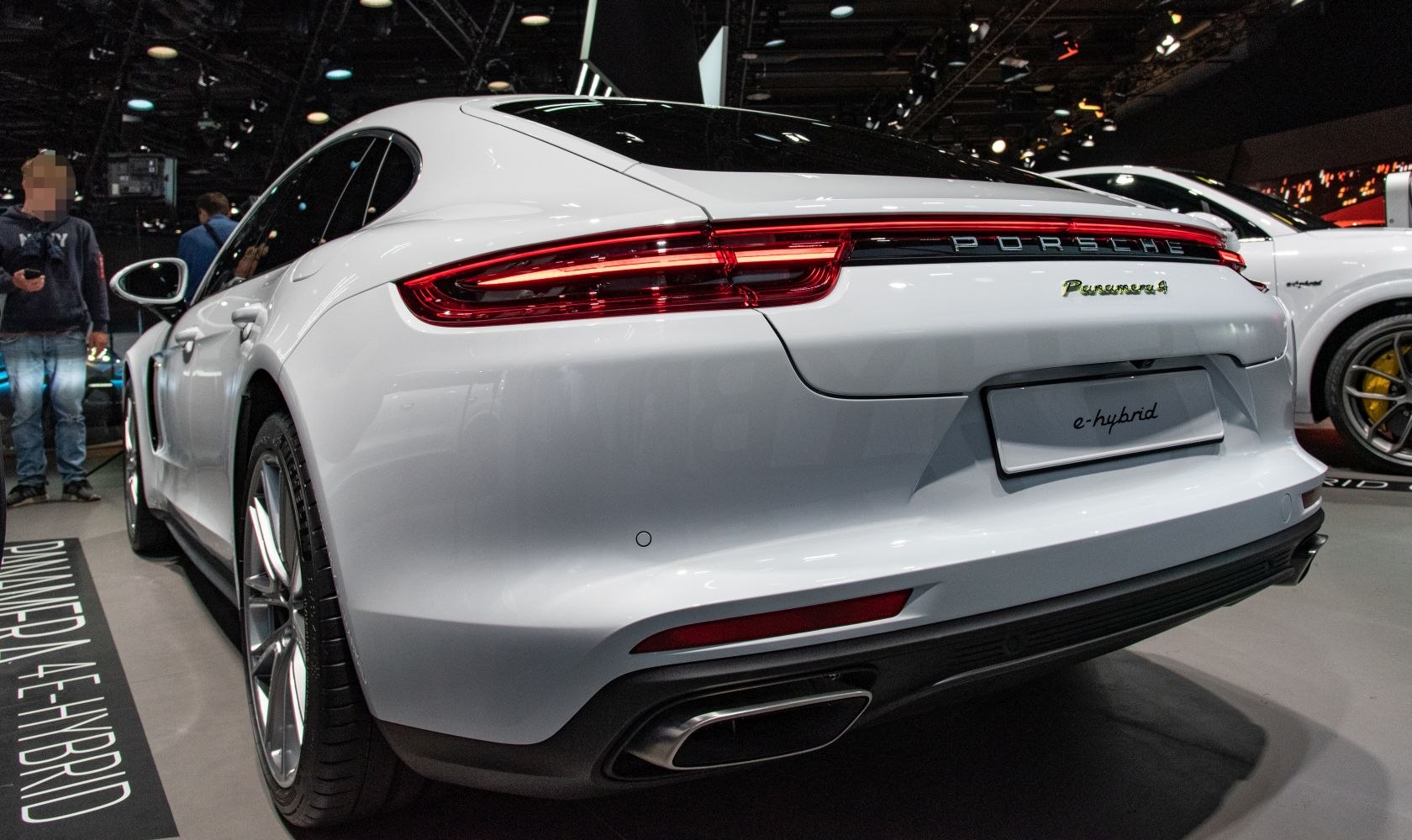 Rear view showing sleek tail lights and dual exhaust of a luxury hybrid sedan.