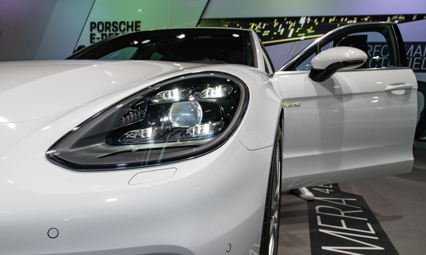 Close-up of LED headlight and front door of white luxury sedan