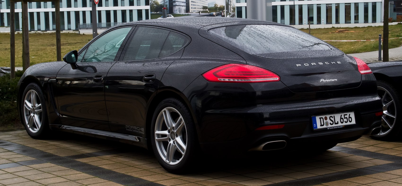 Rear and side profile of sleek black sedan with LED taillights and alloy wheels