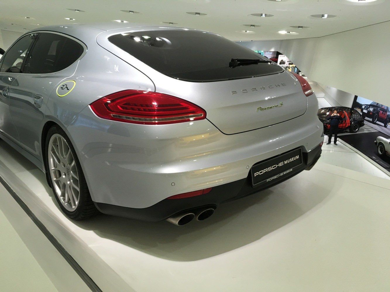 Rear view with red taillights and quad exhausts of silver luxury sedan