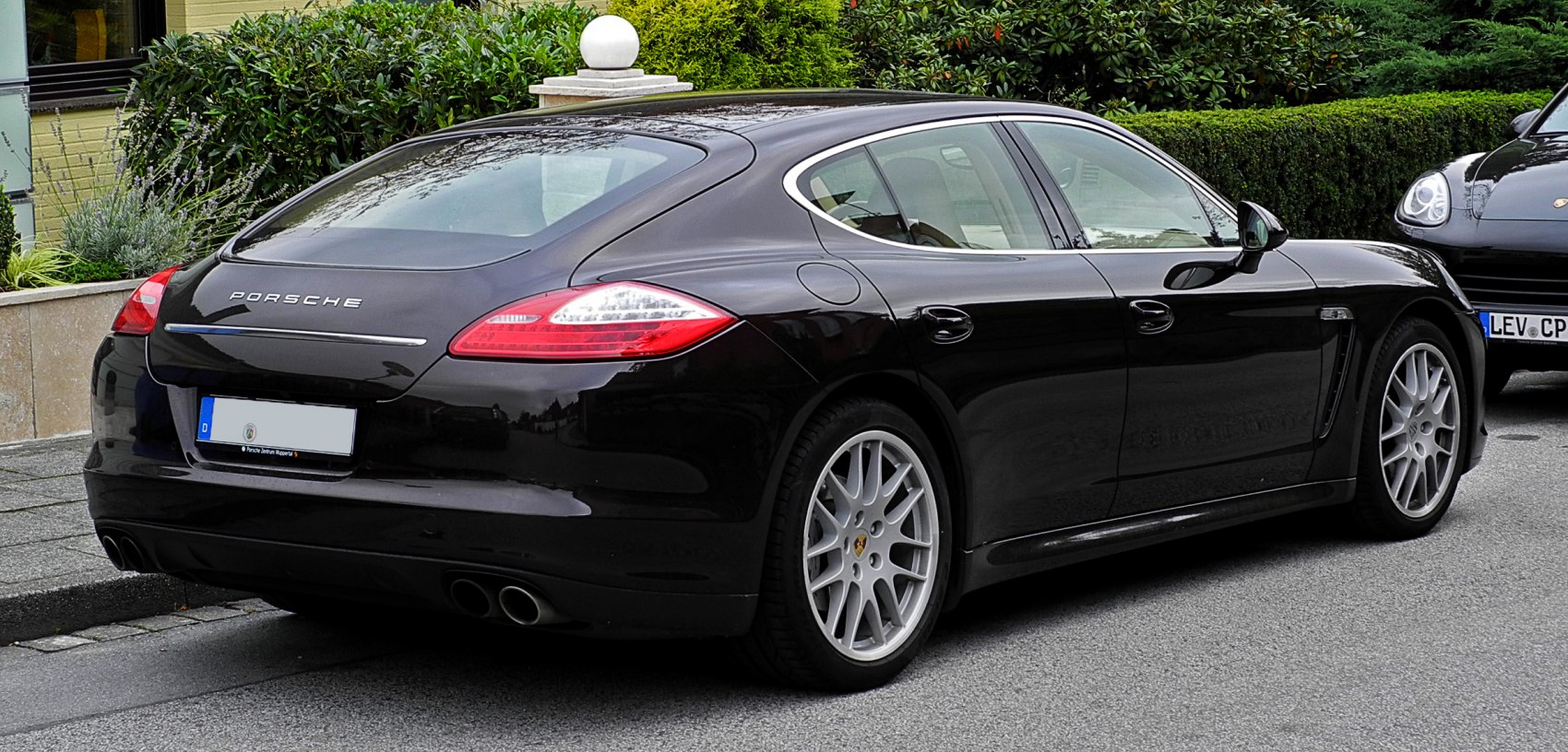 Rear side view of a sleek luxury sports sedan with distinctive taillights and alloy wheels